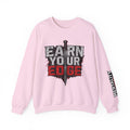 Light pink crew neck sweater with “EARN YOUR EDGE” front graphic and printed sleeve text